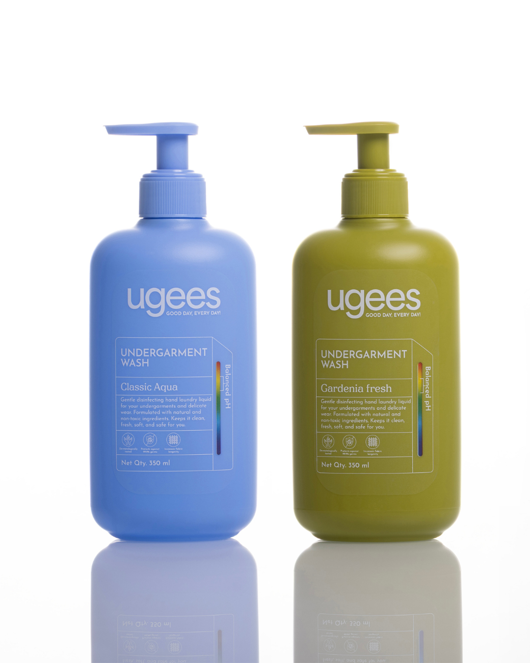 Two pump bottles of Ugees Undergarment Wash on a white background with a reflection below. The left bottle is light blue labeled Classic Aqua, and the right bottle is olive green labeled Gardenia Fresh.