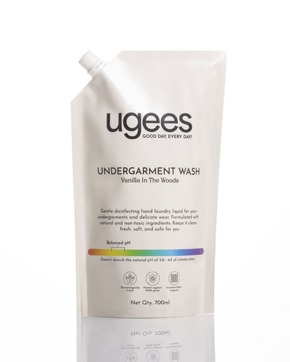 A refill pouch of Ugees Undergarment Wash in Vanilla in the Woods scent, shown on a clean white background with a subtle reflection.