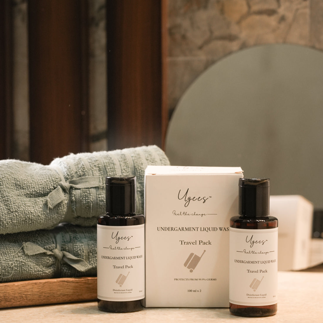 Two bottles of Undergarment Liquid Wash placed next to their packaging box, with a blue towel in the background, all set on a wooden surface.