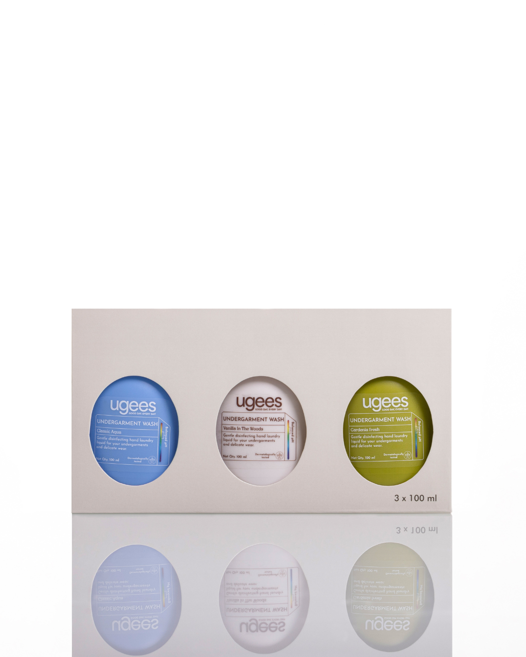 A boxed set of three Ugees undergarment care bottles  presented in a light beige rectangular package with oval cutouts. The set includes a blue bottle, a white bottle and an olive green bottle, with the Ugees brand name visible on each container.